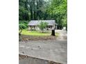 Cozy single-story home features a clean exterior with neutral siding, red shutters and a well-manicured front lawn at 2708 Beacon Dr, Atlanta, GA 30360