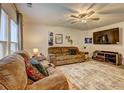 Cozy living room featuring a ceiling fan, large windows, comfy couches, and a large screen television at 336 Freeman Cir, Villa Rica, GA 30180