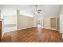 Bright living room with ceiling fan, hardwood floors, and partial wall design leading to other rooms at 467 Ravinia Way, Lawrenceville, GA 30044