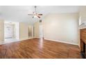 Open-concept living room with hardwood floors, brick fireplace, and access to a closet and front entryway at 467 Ravinia Way, Lawrenceville, GA 30044