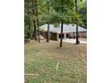 Ranch-style house with a two-car garage and mature trees in the backyard at 2166 Lake Ridge Ter, Lawrenceville, GA 30043