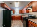 A well-lit kitchen featuring wooden cabinets, black appliances, and durable flooring at 61 Springside Se Dr, Atlanta, GA 30354