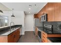 Modern kitchen featuring stainless steel appliances, dark countertops, and sleek wood cabinets at 943 Peachtree Ne St # 1518, Atlanta, GA 30309