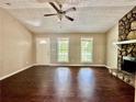 Inviting living room featuring a stone fireplace, wood floors, and natural light from large windows at 186 Grapevine Dr, Douglasville, GA 30134