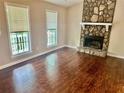 Cozy living room with wood floors, stone fireplace, and sunlit windows at 186 Grapevine Dr, Douglasville, GA 30134