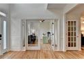Welcoming foyer featuring hardwood floors and French doors leading to a living area with natural light at 3760 Ansley Park Dr, Suwanee, GA 30024