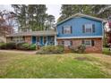 Inviting home featuring a brick facade, blue siding, and a well-maintained front yard at 493 James Street Sw, Lilburn, GA 30047