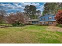 Charming two-story home with a manicured lawn and mature trees, showcasing curb appeal at 493 James Street Sw, Lilburn, GA 30047