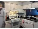 Traditional kitchen featuring white cabinets, black countertops, and a gas range at 6620 Wellington Sq, Norcross, GA 30093
