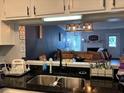 Open kitchen view showcasing the sink area with stainless steel appliances and dark countertops at 6620 Wellington Sq, Norcross, GA 30093