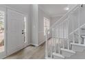 Bright entryway featuring a staircase with white railings, wood floors, and a modern front door at 1706 Brandon Lee Sw Way, Marietta, GA 30008