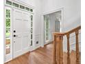 Bright entryway featuring hardwood floors, a white door with sidelights, and a staircase at 2010 Pearwood Path, Roswell, GA 30076