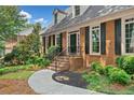 Close-up of a brick home featuring a landscaped yard, walkway, and black shutters at 2010 Pearwood Path, Roswell, GA 30076