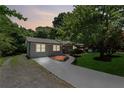 Charming one-story home with a well-manicured lawn and newly paved driveway at dusk at 2060 Panstone Sw Ct, Marietta, GA 30060