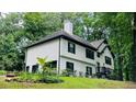 Charming two-story home with white siding, black trim, and lush green surroundings, offering a serene retreat at 2985 Heather Stone Way, Lawrenceville, GA 30043