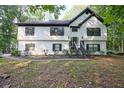 Two-story home featuring mature trees, a chimney, black shutters, and a well-maintained front yard at 2985 Heather Stone Way, Lawrenceville, GA 30043