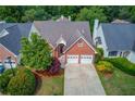 An aerial view showcasing the charming brick home and the lush greenery of its landscaped surroundings at 3585 Berkeley Park Ct, Duluth, GA 30096
