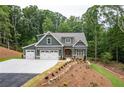 Picturesque home displaying a three-car garage and a well-maintained landscape at 7080 Driskell Cir, Cumming, GA 30041