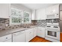 Bright kitchen featuring white cabinets, updated appliances, and a stylish backsplash at 1891 8Th St, Atlanta, GA 30341