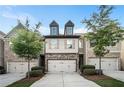 Beautiful townhome with a two-car garage, manicured landscaping, and a stone facade at 2909 Emme Ct, Conyers, GA 30094