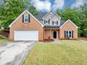 Well-maintained two-story brick home featuring an attached two-car garage at 3190 Water Brook Sw Dr, Conyers, GA 30094