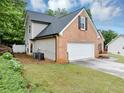 View of brick home showcasing the side yard and attached two-car garage at 3190 Water Brook Sw Dr, Conyers, GA 30094