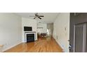 Spacious living room with hardwood floors, a fireplace, and a ceiling fan at 4965 N Bridges Dr, Alpharetta, GA 30022