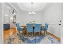 Dining room featuring a chandelier, hardwood floors, blue chairs, and natural light at 827 Holly Rdg, Canton, GA 30115