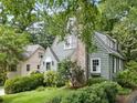 Quaint house exterior showcasing its architectural details with mature landscaping and green lawn at 2054 Palifox Ne Dr, Atlanta, GA 30307