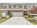 Townhome exteriors with stone accents, two-car garages, and manicured landscaping at 2340 Manor Pointe Dr, Cumming, GA 30041