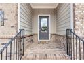 Inviting front porch with brick flooring, a gray front door, and decorative address at 2340 Manor Pointe Dr, Cumming, GA 30041