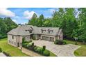 Beautiful brick home featuring manicured landscaping, three-car garage, basketball court, and brick and stone accents at 241 Russell Rd, Lawrenceville, GA 30043
