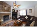 Cozy living room with a stone fireplace, plush sofa, and warm lighting for a relaxing atmosphere at 236 Hiram Sudie Rd, Dallas, GA 30157