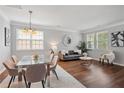 Open-concept living room with hardwood floors, dining table, sofa, and bright natural light at 2840 Brookford Sw Ln, Atlanta, GA 30331