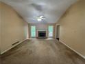 Expansive living room featuring a cozy fireplace, two large windows, and a ceiling fan for added comfort at 134 Summer Lake Dr, Dallas, GA 30157