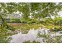 Scenic view of a tranquil pond reflecting the surrounding trees and building at 1666 Oakbrook Lake Dr, Norcross, GA 30093