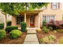Inviting entrance with a brick facade, trimmed shrubs, and a well-maintained lawn at 4916 Gathering Pl, Suwanee, GA 30024