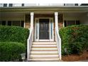 Front door flanked by sidelights and stone accents, enhanced with manicured hedges at 111 Bexley Ln, Douglasville, GA 30134
