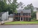 Beautiful two-story brick home with a manicured lawn and a two-car garage at 7593 Watson Bay Ct, Stone Mountain, GA 30087