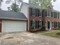 Exterior view of home showing two-car garage, brick and siding, and manicured yard at 7593 Watson Bay Ct, Stone Mountain, GA 30087