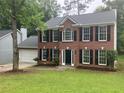 Traditional brick home featuring a well-manicured lawn and a two-car garage at 7593 Watson Bay Ct, Stone Mountain, GA 30087