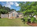 Charming home exterior featuring lush green lawn, mature landscaping, stone accents, and a fenced yard at 109 Rockefeller Ln, Dallas, GA 30157