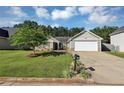 Inviting exterior view of a home showcasing its manicured lawn, mature tree, and a two-car garage at 109 Rockefeller Ln, Dallas, GA 30157