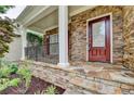 Close-up view of the front porch with stone accents and a red front door at 4495 Hedgewood Dr, Cumming, GA 30041
