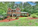 Traditional brick home with a lush lawn and mature trees in a peaceful setting at 2530 Ashbourne Dr, Lawrenceville, GA 30043