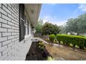 Landscaped front yard with flowering garden, brick accents, and a driveway under a cloudy sky at 3664 Pin Oak Cir, Atlanta, GA 30340