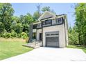 Beautifully landscaped modern home with balcony, grey garage door, and inviting curb appeal at 4366 Bradley Sw Dr, Snellville, GA 30039