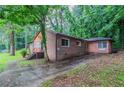 Side exterior view of a brick home with a paved driveway and green landscape at 2046 Rector Sw Dr, Atlanta, GA 30311