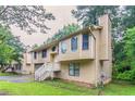 Side view of a split-level home showcasing the siding, window details, and well-maintained landscape at 2218 Lowtrail Ct, Lithonia, GA 30058