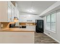 Cozy kitchen features white cabinetry, black appliances, butcher block countertops and wood-look flooring at 2218 Lowtrail Ct, Lithonia, GA 30058